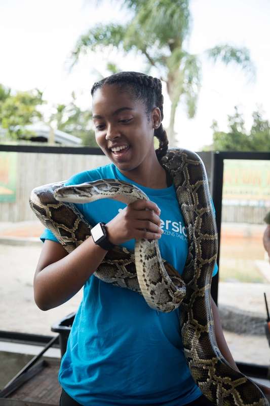 Student holds a snake on an Immersion experience in the Everglades.