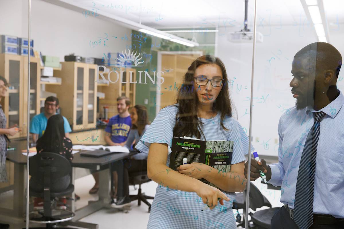 Two Rollins College students work on a formula in an industrial math class.