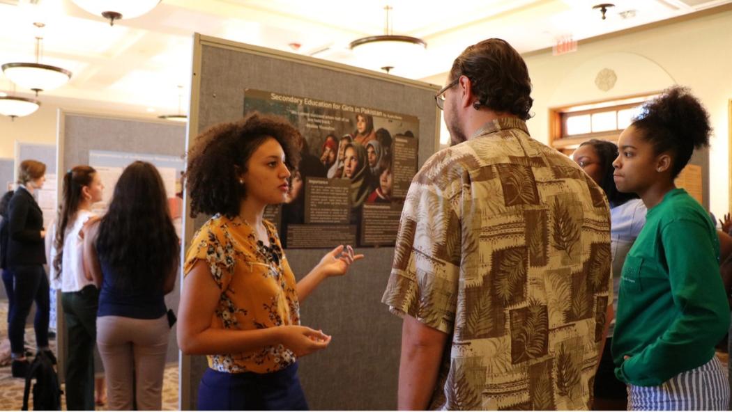 Social entrepreneurship student presents their research at a poster session.