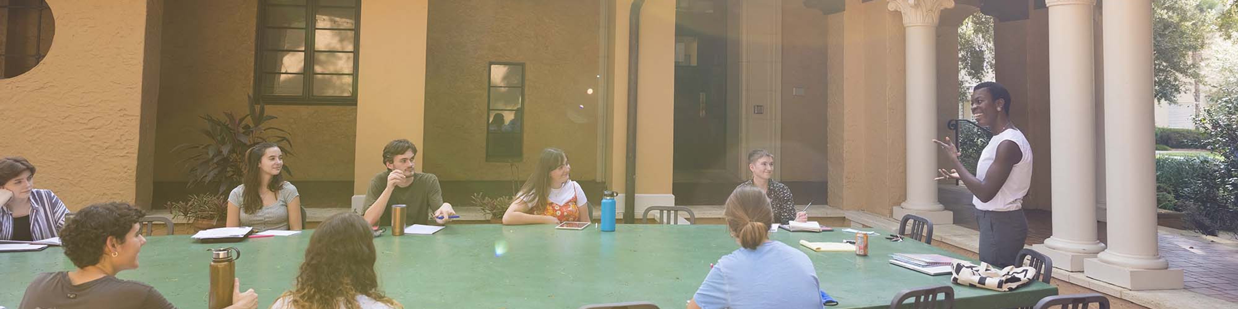 Students and a professor have a discussion at an outdoor classroom on 鶹ƵAPP campus.