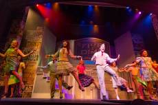 Students dance during a musical on the Annie Russell Theatre stage.