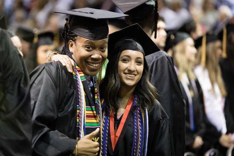 Two students in commencement attire.