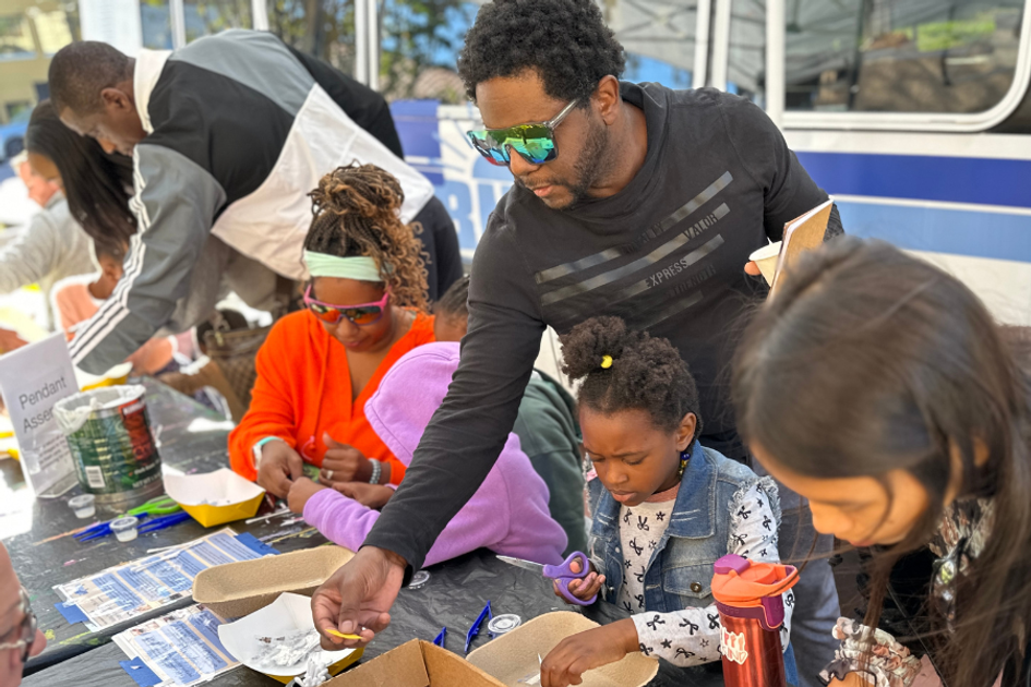 Families make art at an outdoor table during Fall Fling at Rollins Museum of Art