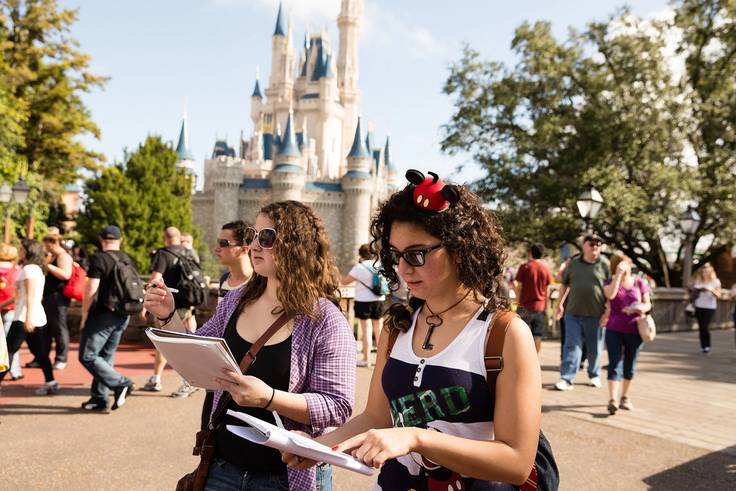 Two students do a class project at the Magic Kingdom in Disney World.