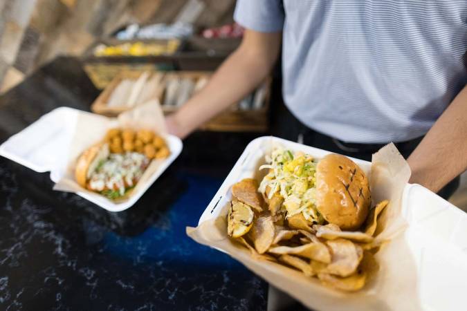 A fresh fish sandwich with pineapple salsa and chips