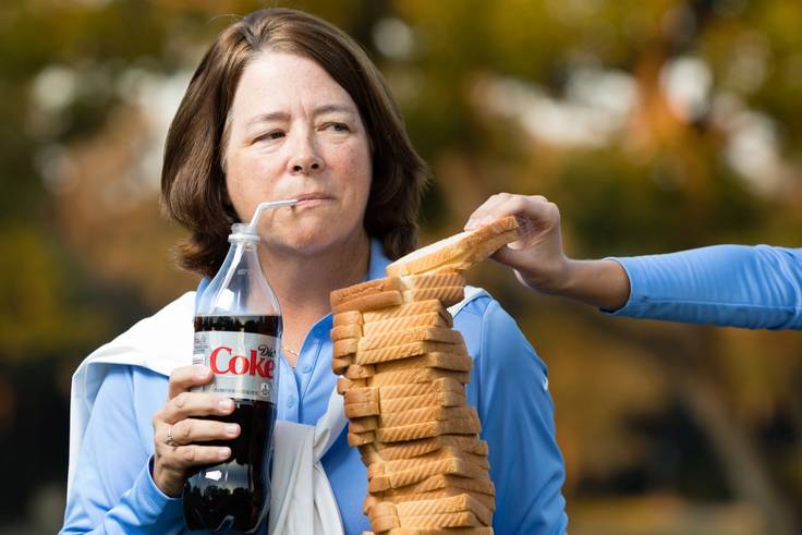 Julie Garner holding a stack of white bread and a diet Coke.
