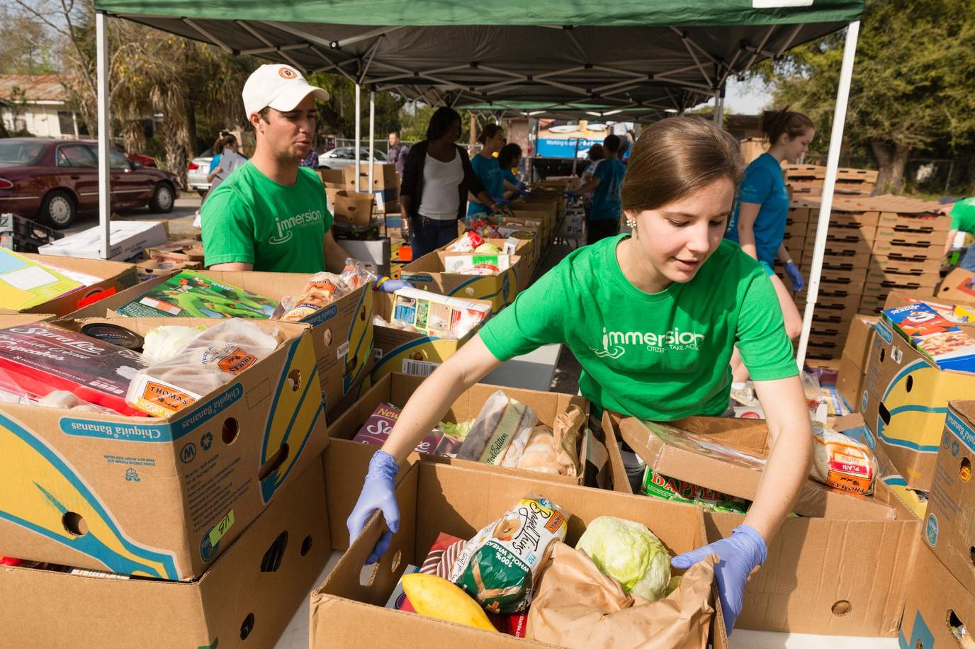 Rollins students help sort food donations into boxes.