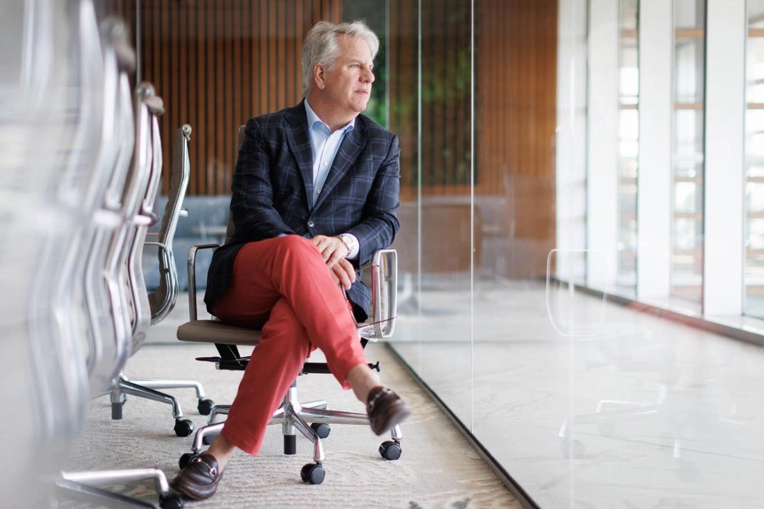 Sam Hocking sits alone on a conference room looking out the window.