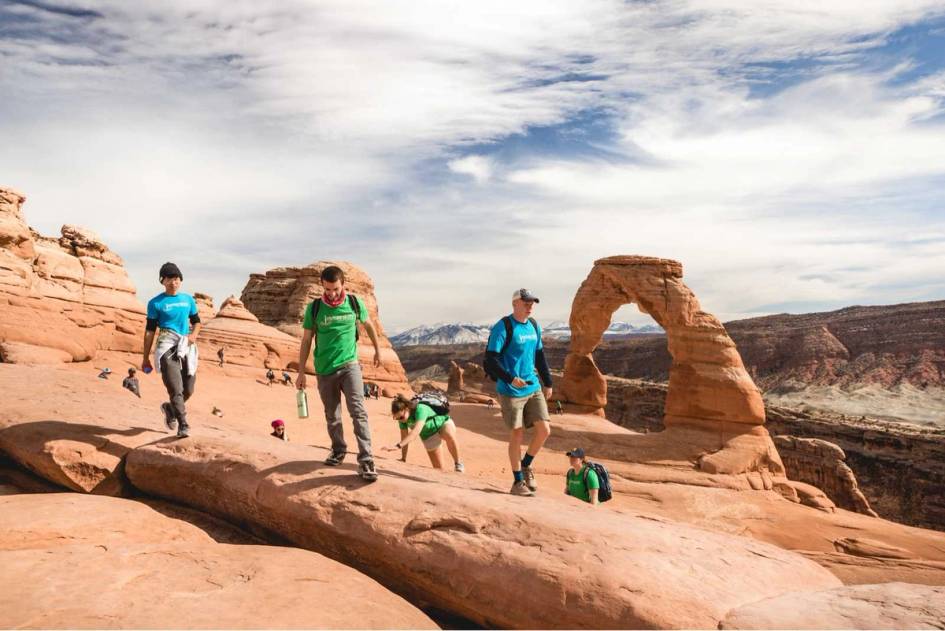 A group of students hikes through Arches national park.