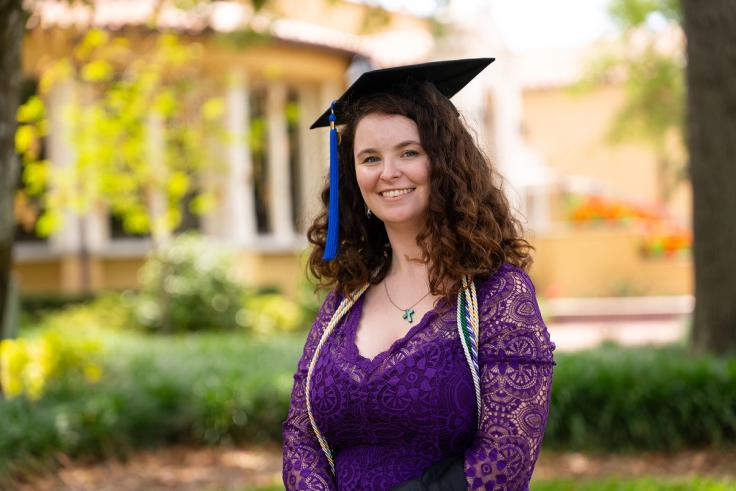 Maggie Kuffskie in graduation regalia on Rollins campus.