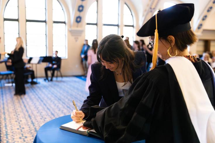 Sydney Boswell signing the book at the Phi Beta Kappa induction ceremony. 