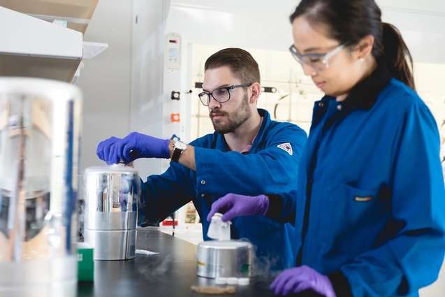 A chemistry professor helping a student in the chemistry lab.