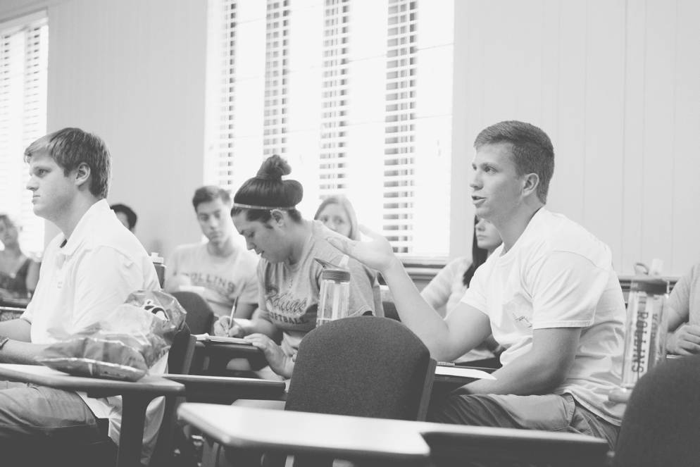 A philosophy student speaking to professor Smaw from his desk.