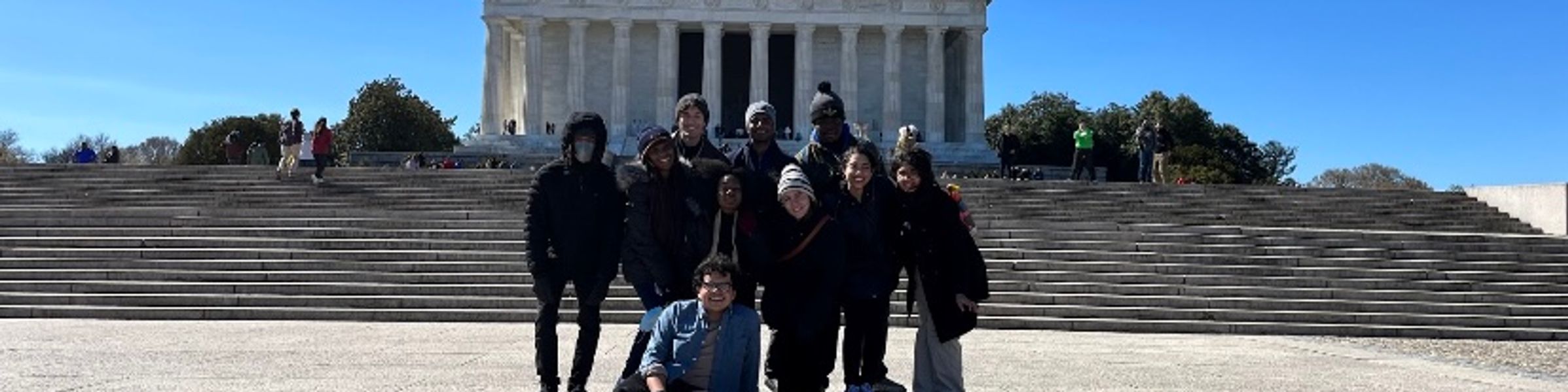 A group of Rollins College student pose in front of a monument during a trip to Washington, DC.