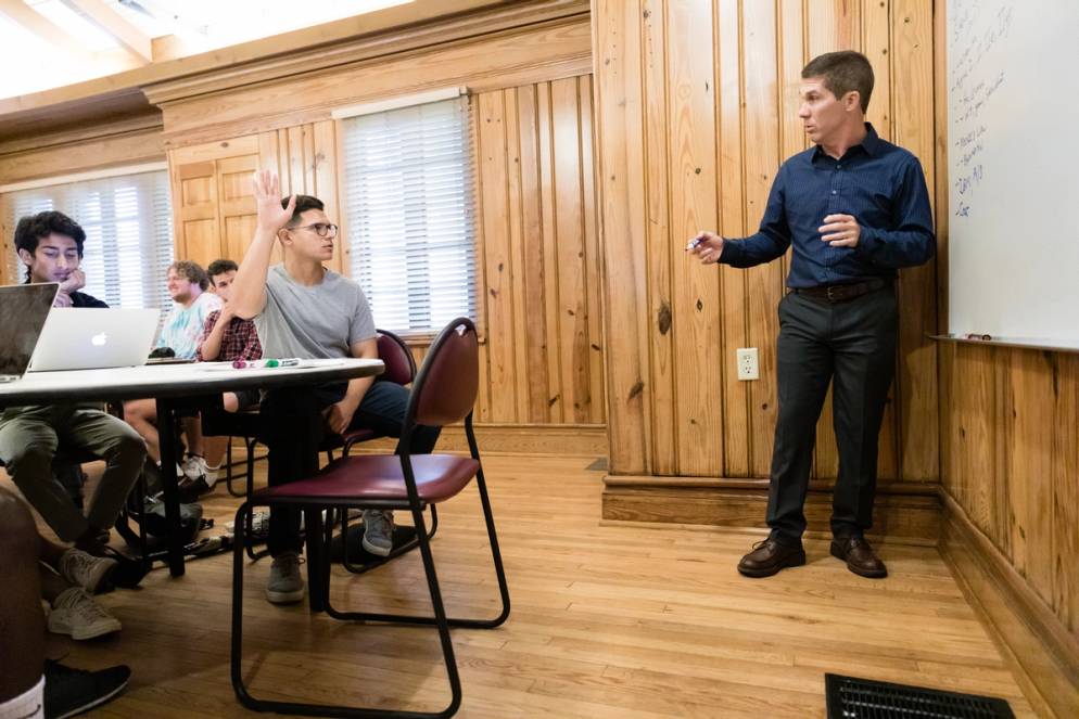 Student raises his hand in a business management class.