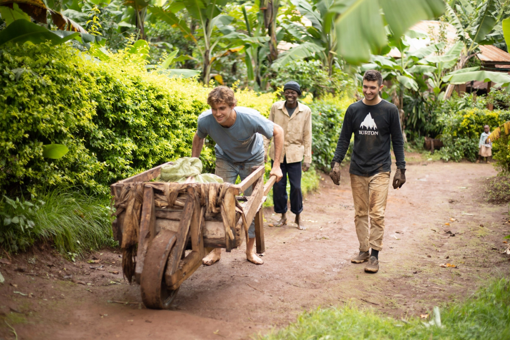 Student pushing a wheelbarrow up an incline in the village of Mkyashi, Tanzania.