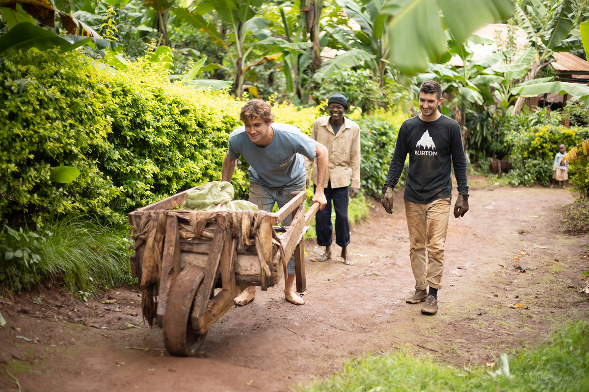 A Rollins student pushing a wheelbarrow.