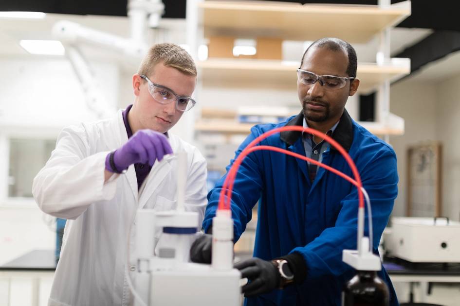 A chemistry student and professor work one on one in a lab.