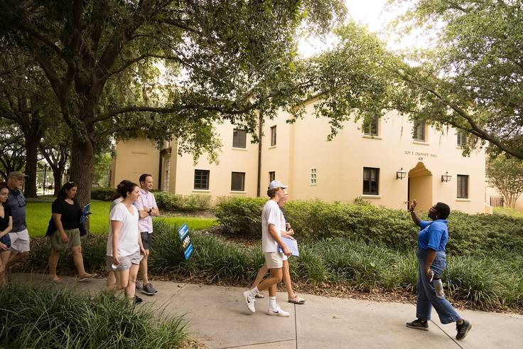 A tour guide leads people through the Rollins campus.