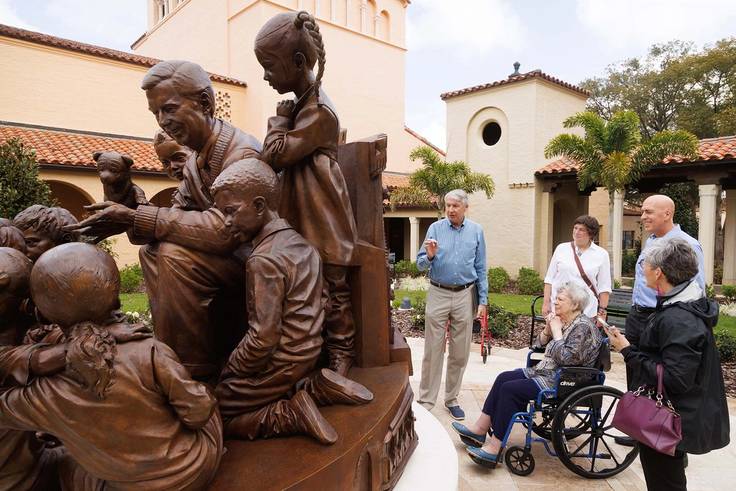 President Grant Cornwell led a small crowd past A Beautiful Day for a Neighbor, the brand new statue honoring the work of Rollins’ most beloved alumnus. 