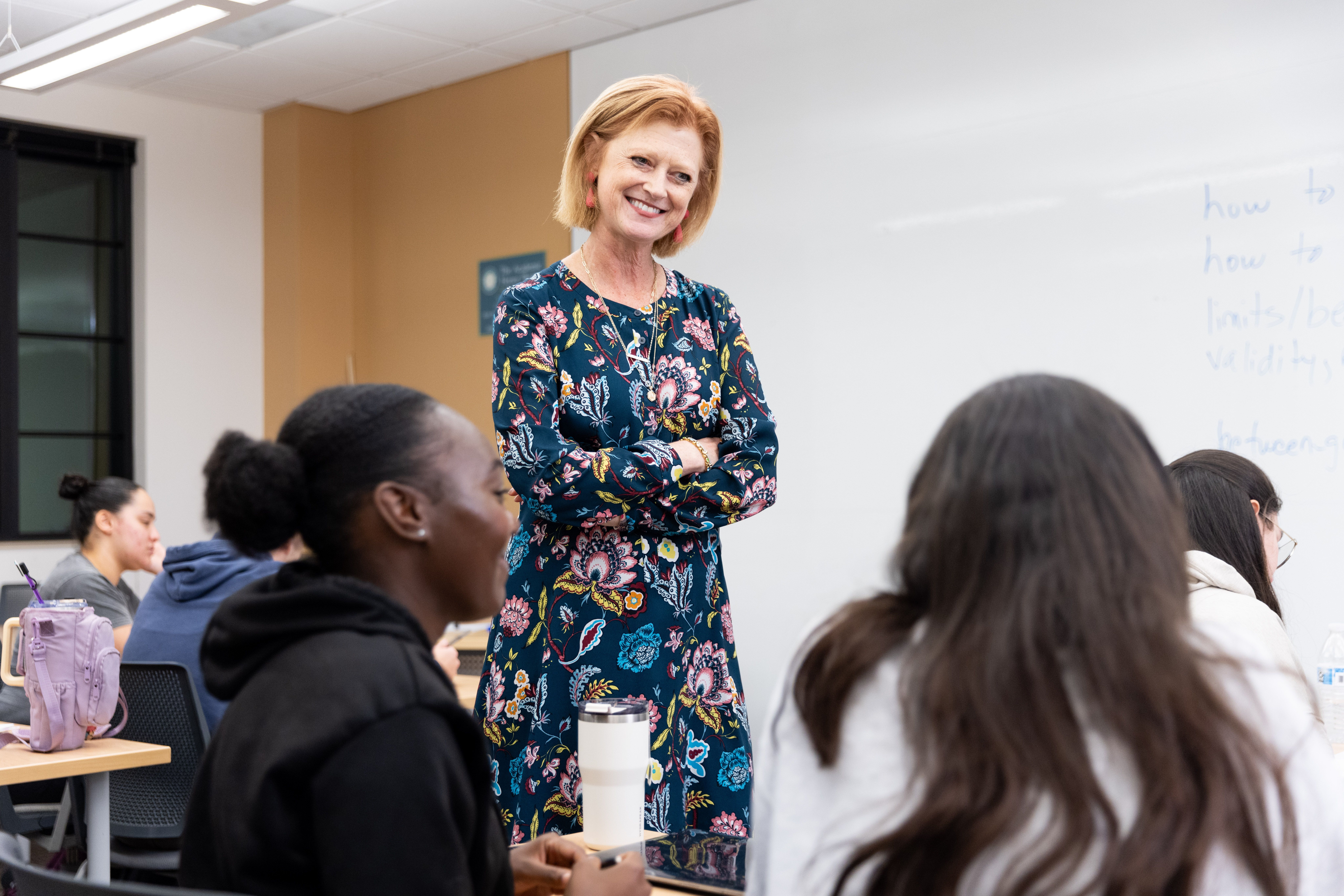 An applied behavior analyst takes notes as a young patient writes in a notebook.