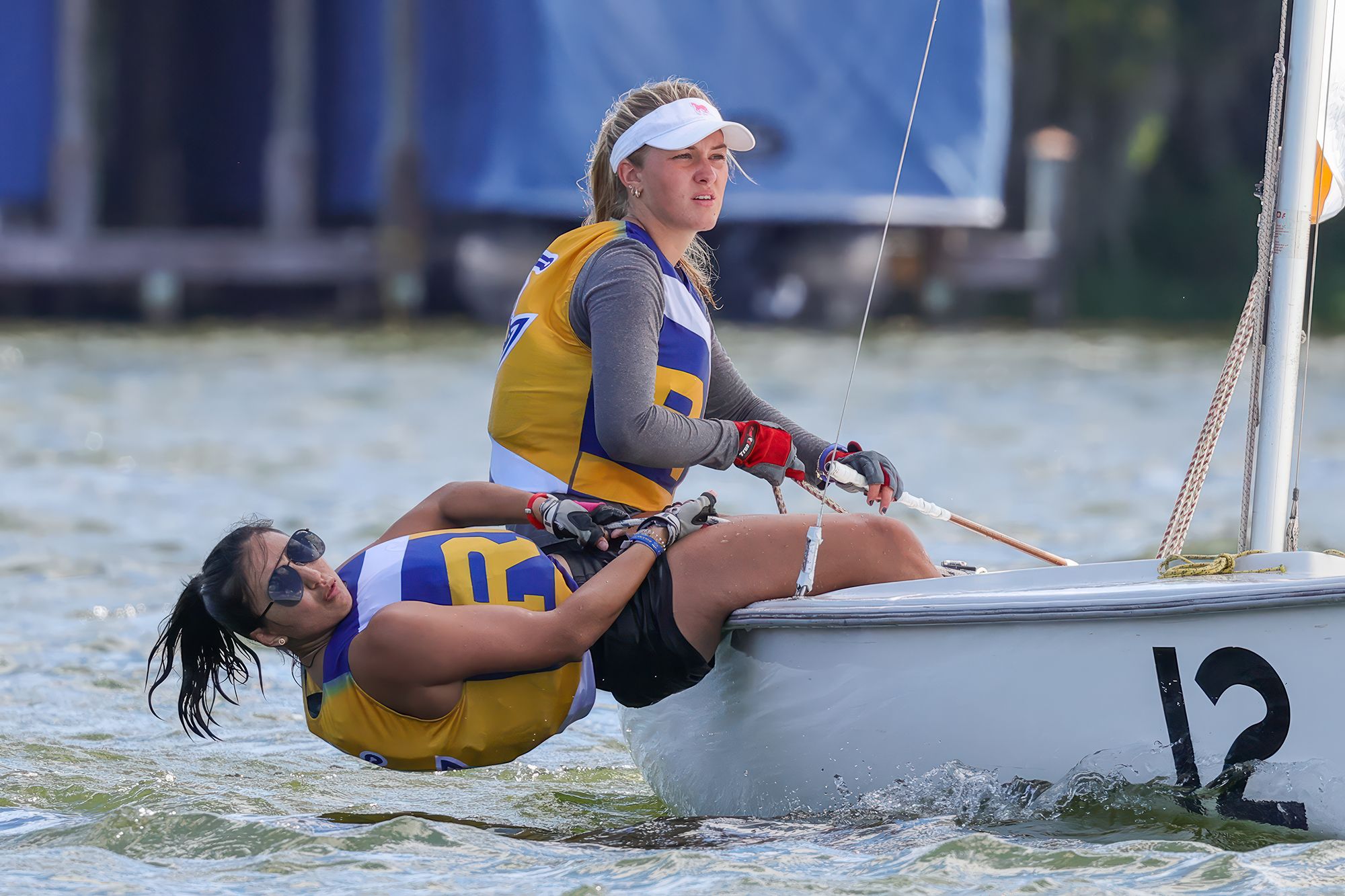 Two sailors navigate a boat on Lake Virginia.
