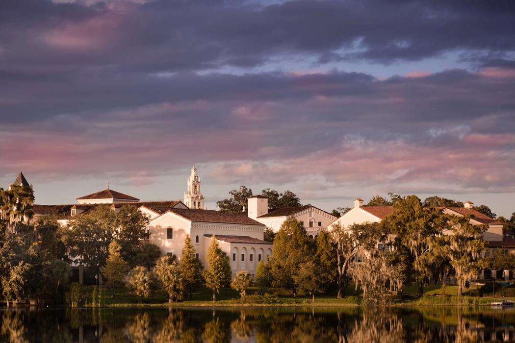 Rollins Campus sitting along Lake Virginia with a cloudy sky of pinks and purples.