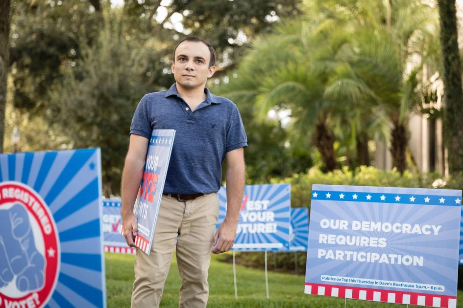 Skylar Knight ’19 plants yard signs on campus to encourage voter participation and civic awareness.