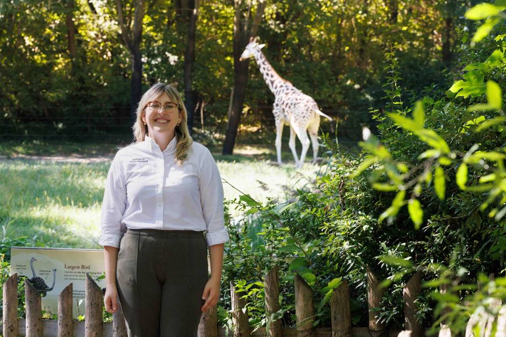 Zoe Mack at the Bronx Zoo pictured in front of a giraffe