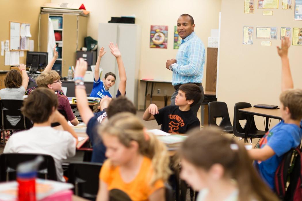 A Rollins student teaches a group of elementary students.