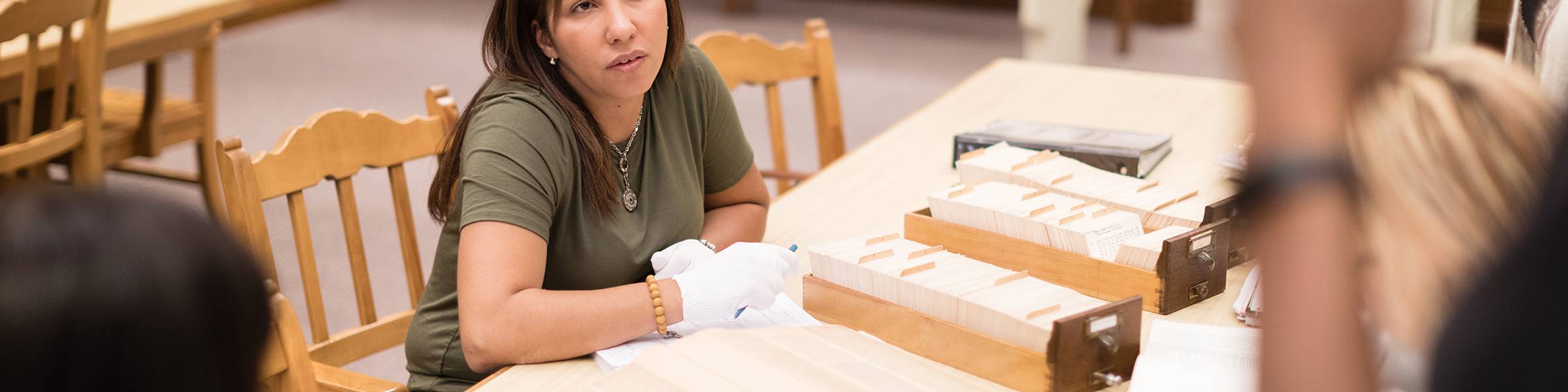 Two students discuss an idea while conducting research in the archives.