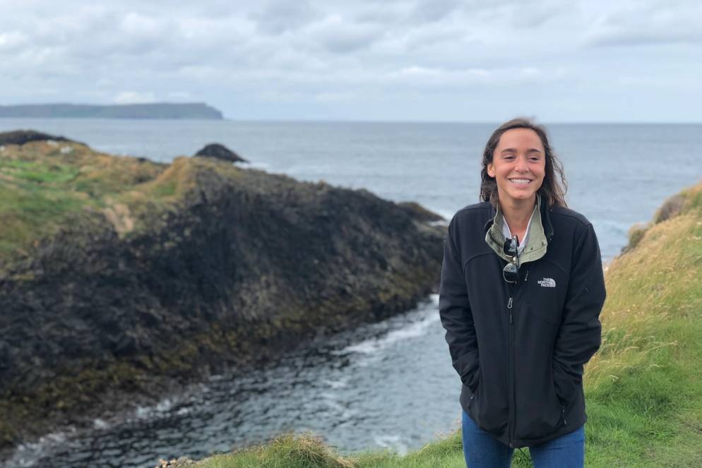 A student poses on seaside cliffs in Ireland.