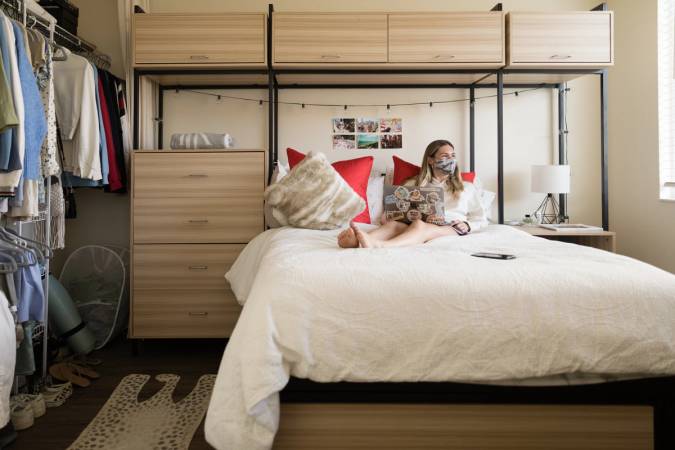 A student relaxes in her Lakeside neighborhood dorm room.