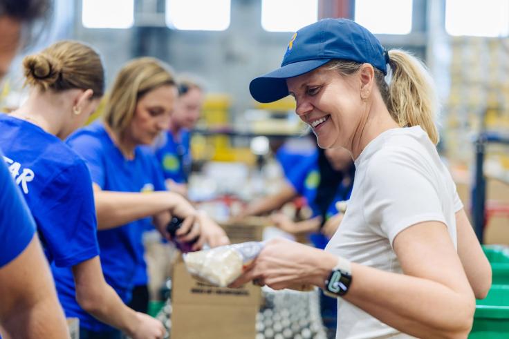 Rollins president Brooke Barnett and students pack meals at Second Harvest Food Bank