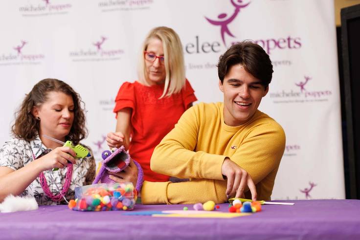 A student and professor creating puppets as emotional therapy for those affected by trauma.