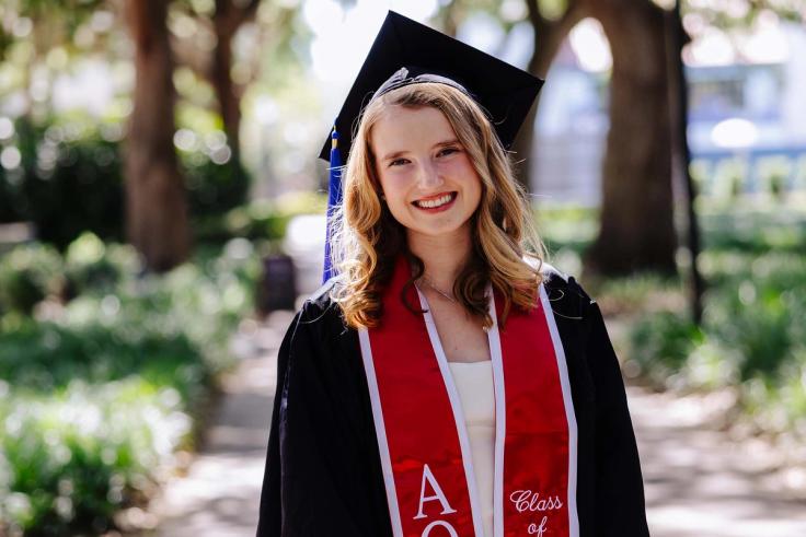 Emma Salerno in a graduation cap and gown with a red stole.