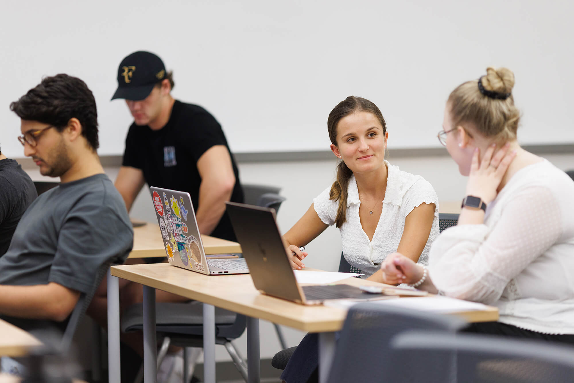 A students smiles at a classmate during an economics class.