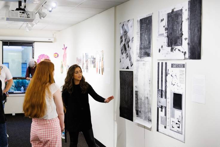 Emma Lostutter ’23 explaining her art exhibition to a fellow student.