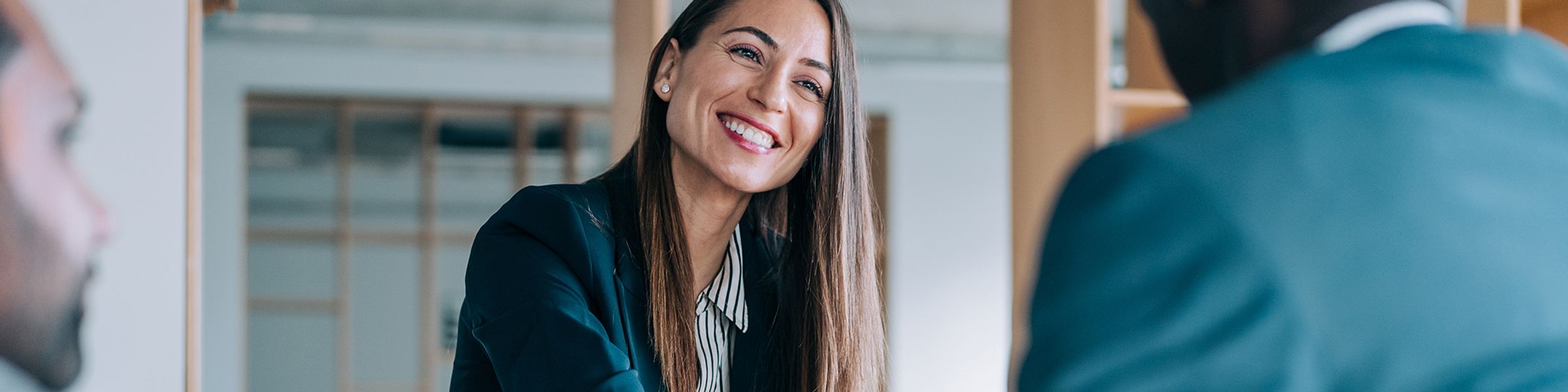 A human resources professional shakes the hand of a new hire.