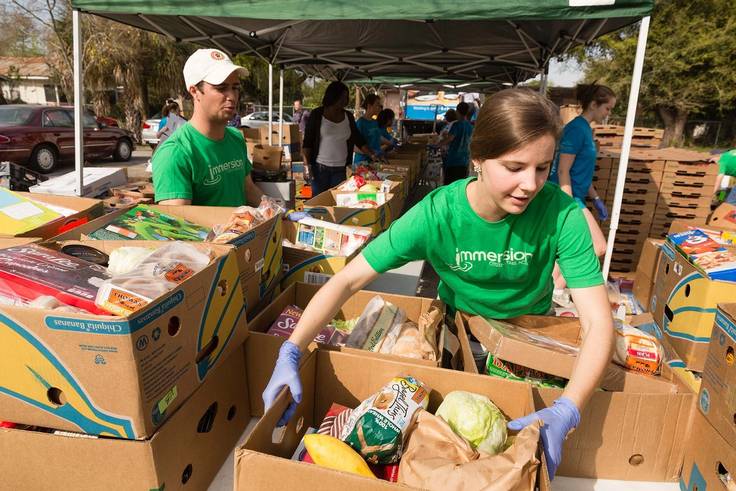 Students pack boxes with food for a food drive