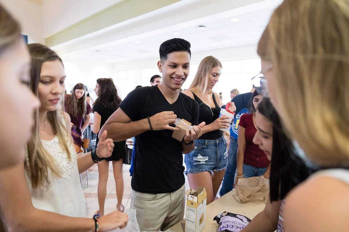 Students gather together to make s’mores in a college dining hall.
