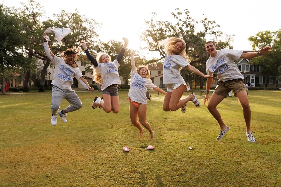 Students jumping up and down on Mills Lawn with excitement for Fox Day.