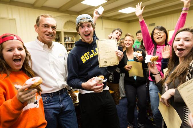 Students celebrating with the Rollins president as he signs the Fox Day declaration.