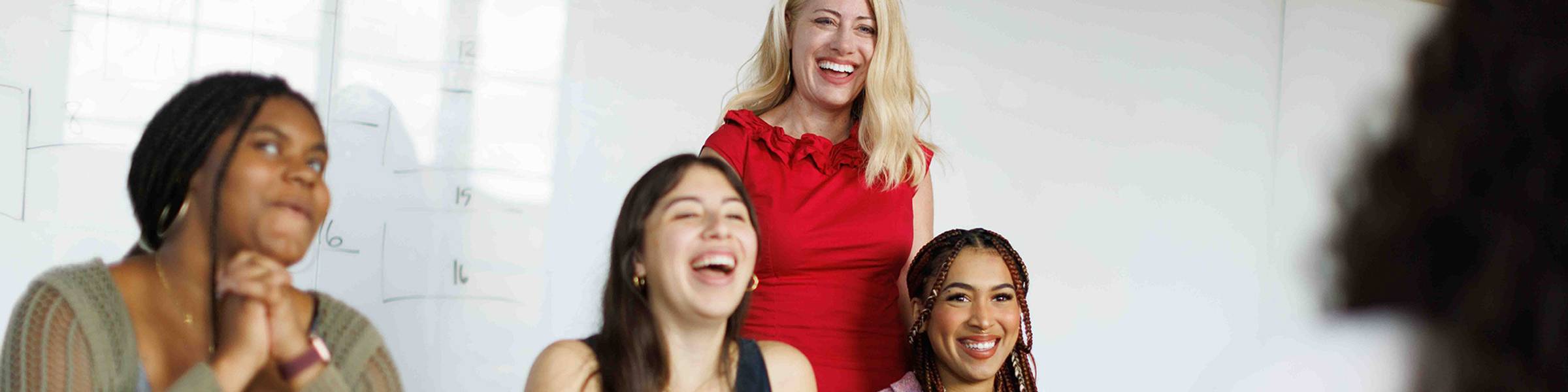 English professor and students laughing during a class discussion
