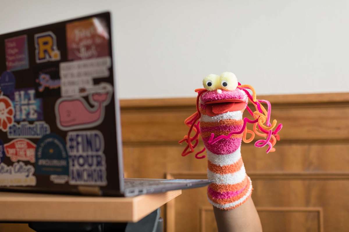 A student holds a sock puppet up during a digital puppet making workshop