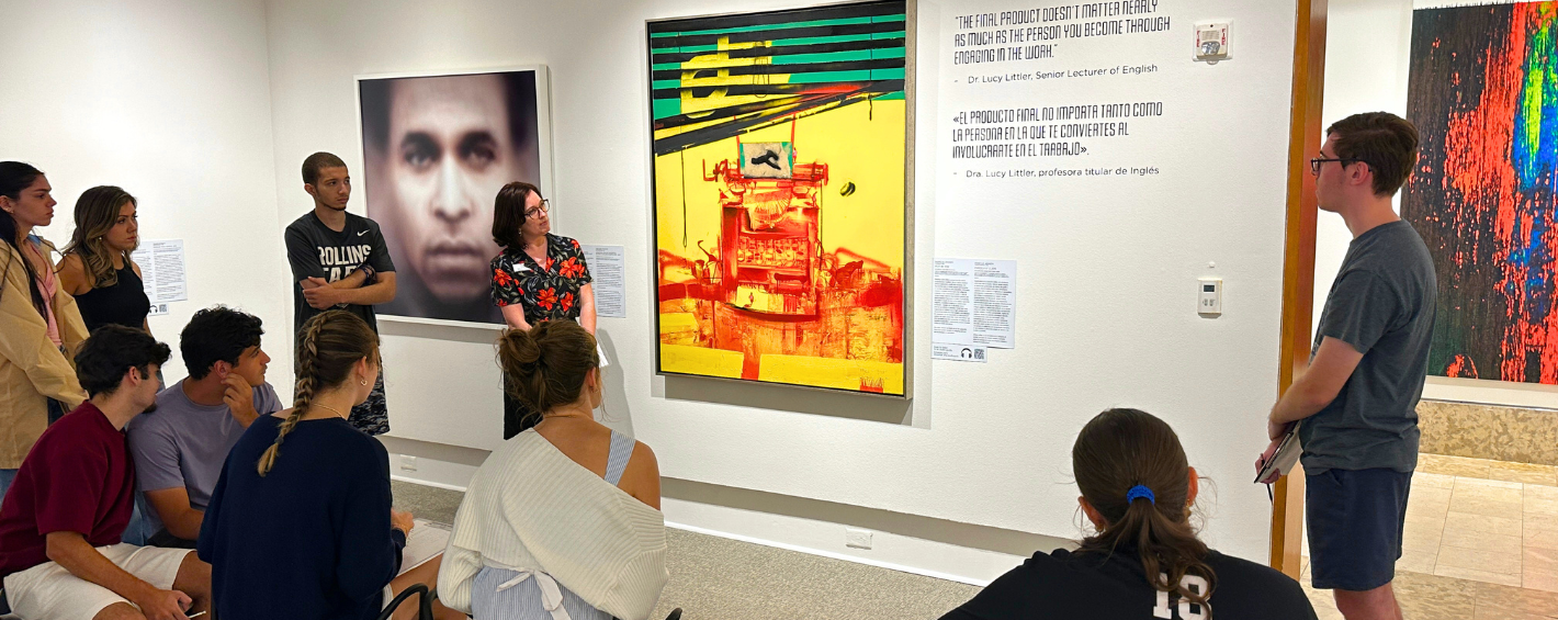 College students gather around a facilitator surrounded by artworks in Rollins Museum of art gallery