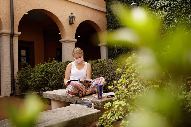 Student studying in the Cornell Hall courtyard.