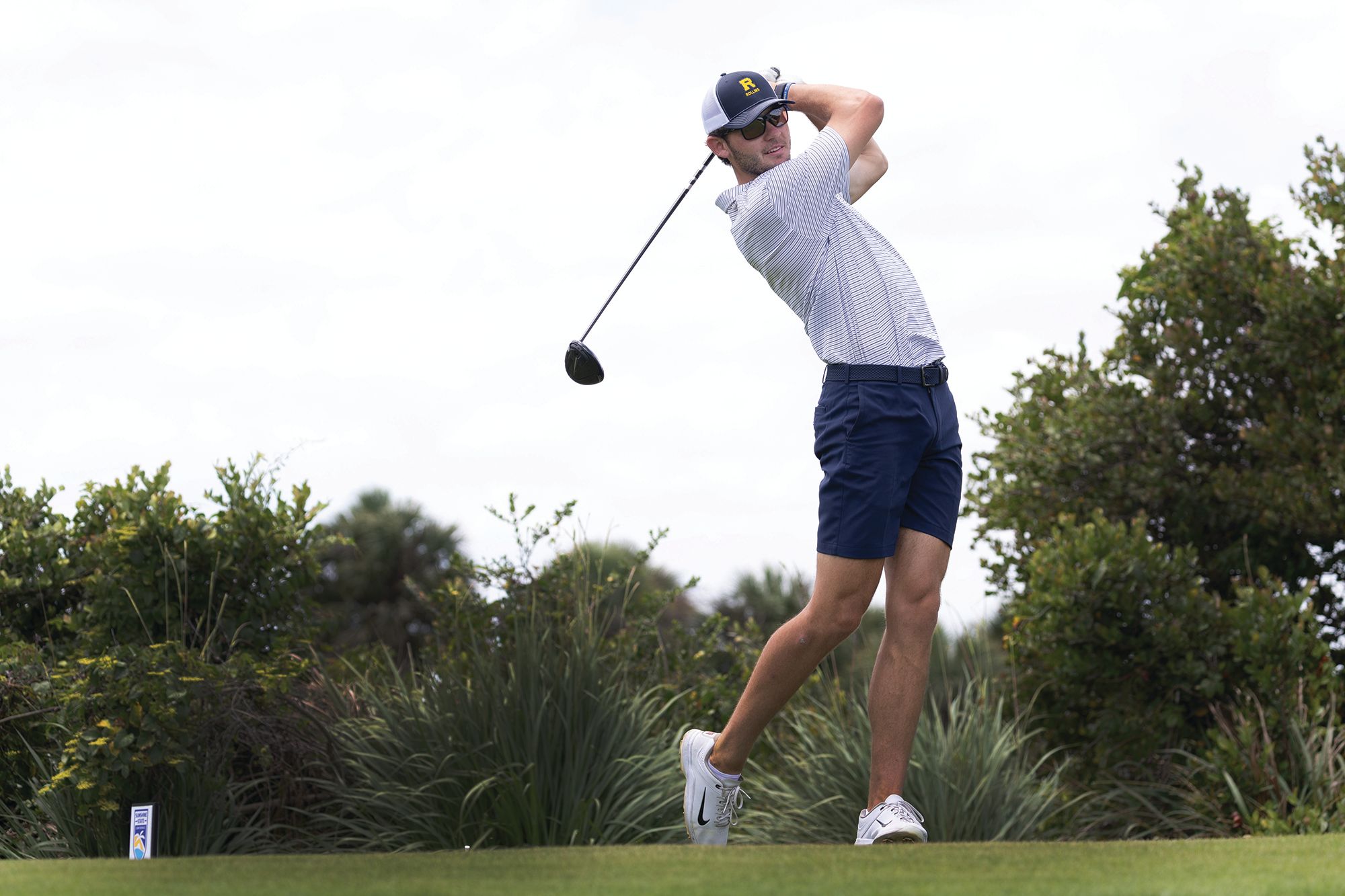 A golfer drives a ball from the tee.