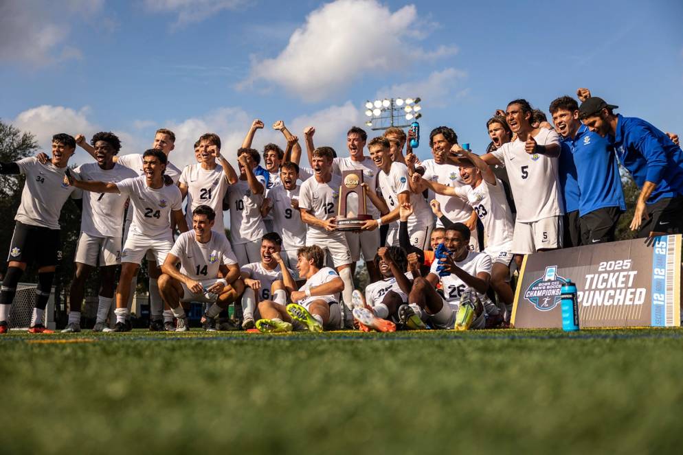 The Rollins men's soccer team poses with the regional champion trophy after winning a quarterfinal match.