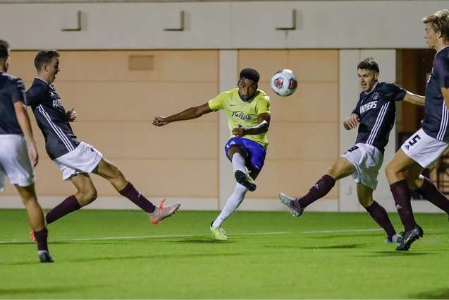 A soccer player breaking through several defenders during a game.